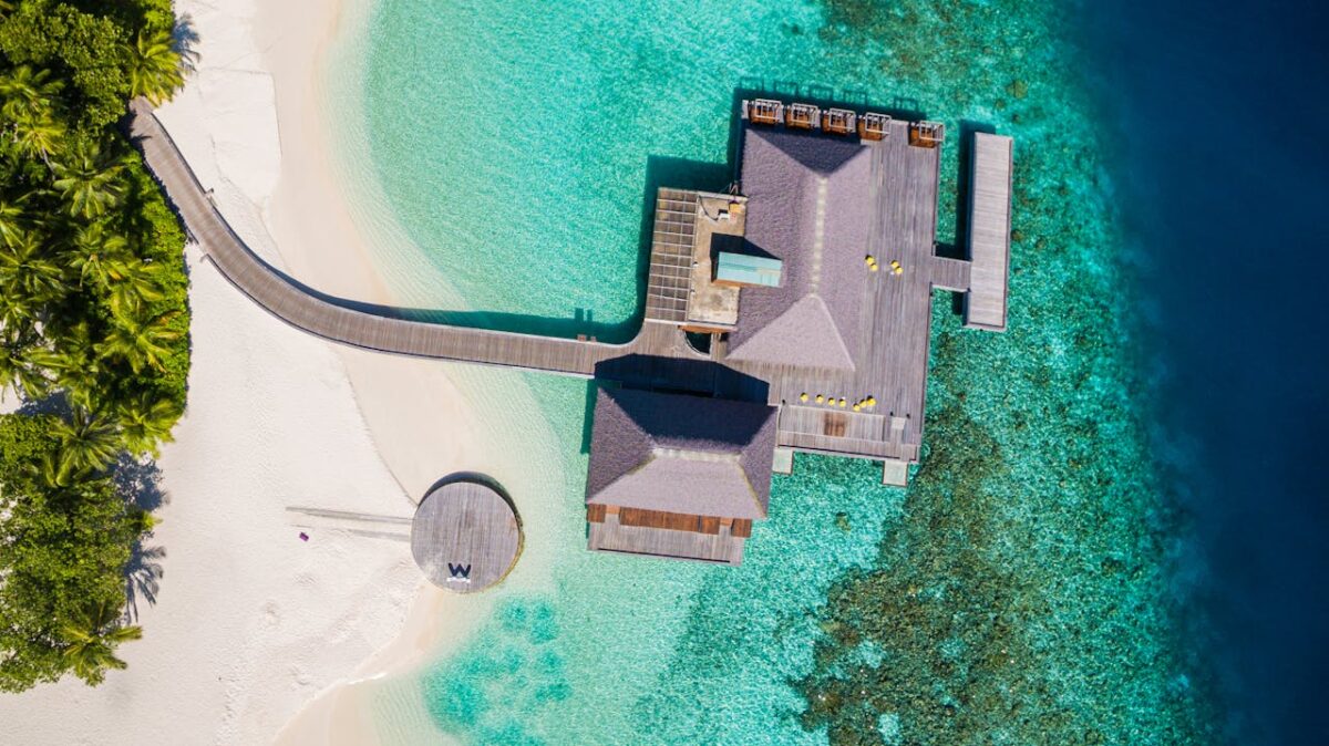 Stunning aerial photo of an overwater bungalow and turquoise waters in Maldives.